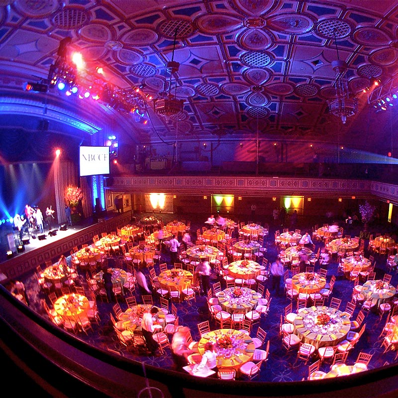 nbccf-gala3 A large room designed for dining, showcasing multiple tables and chairs set up for an upcoming dinner gathering.